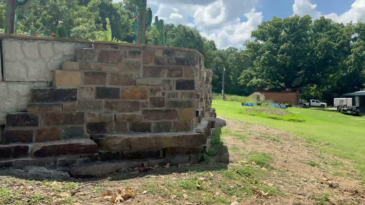 Semi-inground pool rock surround on a sloped Tulsa yard