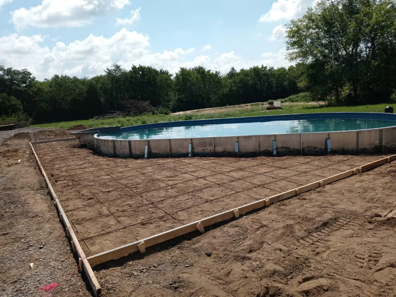 Semi-inground pool on sloped Tulsa backyard